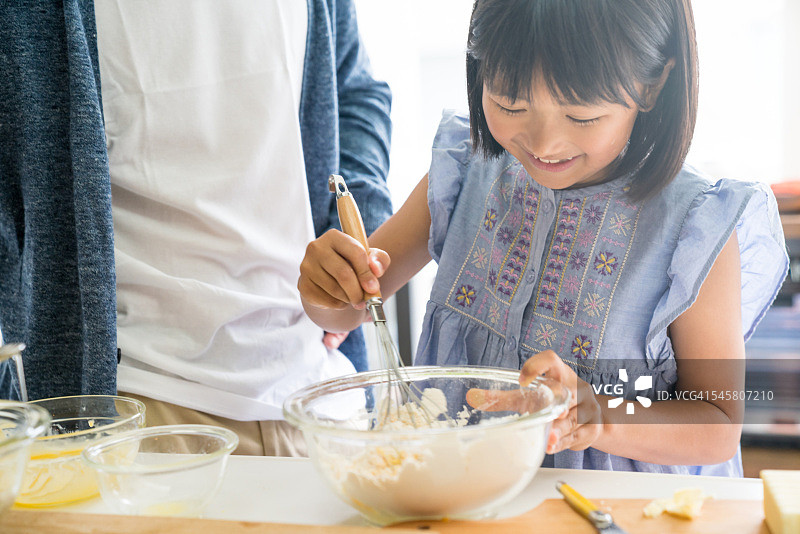 女儿和父亲一起烘焙，快乐亲子时光图片素材