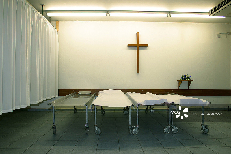 房间里空旷的担架，墙上有十字架图片素材