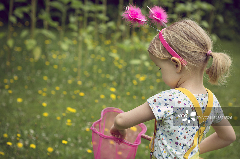 在花园里拿着捕蝶网的儿童图片素材