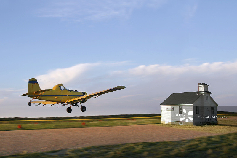 农用飞机飞向农舍图片素材