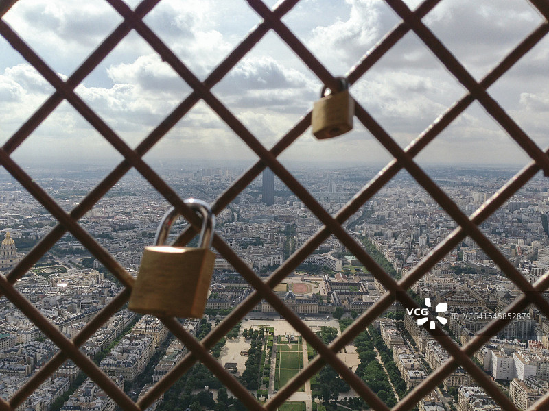 埃菲尔铁塔上的爱情锁，背后是巴黎城市图片素材