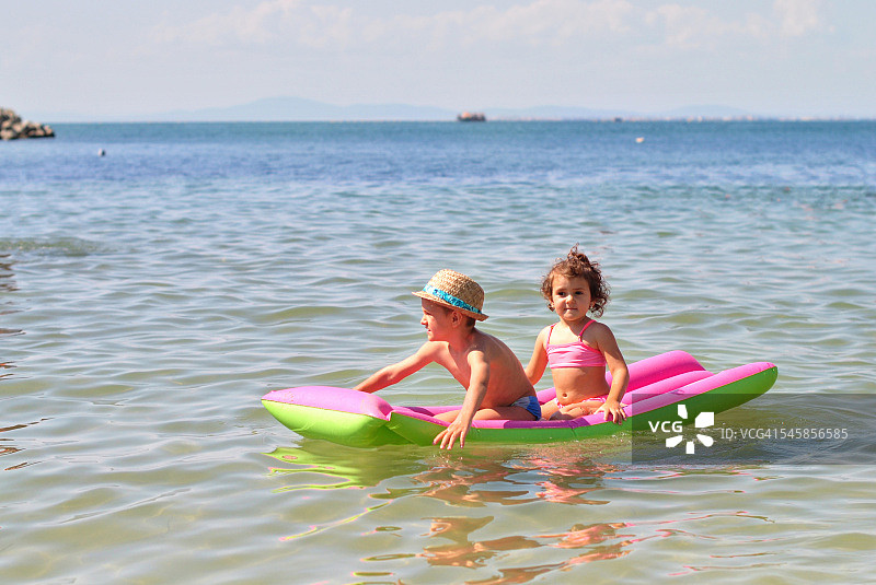 兄妹（2-3岁，4-5岁）在充气船上游泳图片素材