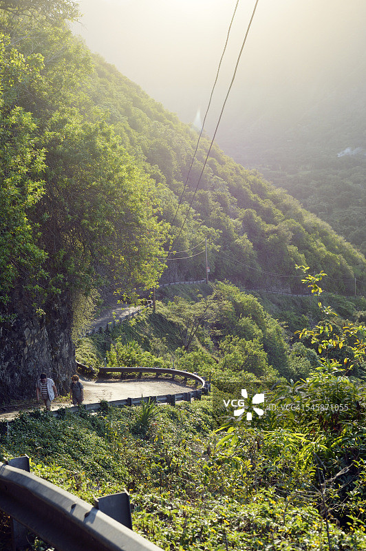 美国夏威夷大岛：傍晚时分在怀皮奥山谷中徒步的两人图片素材