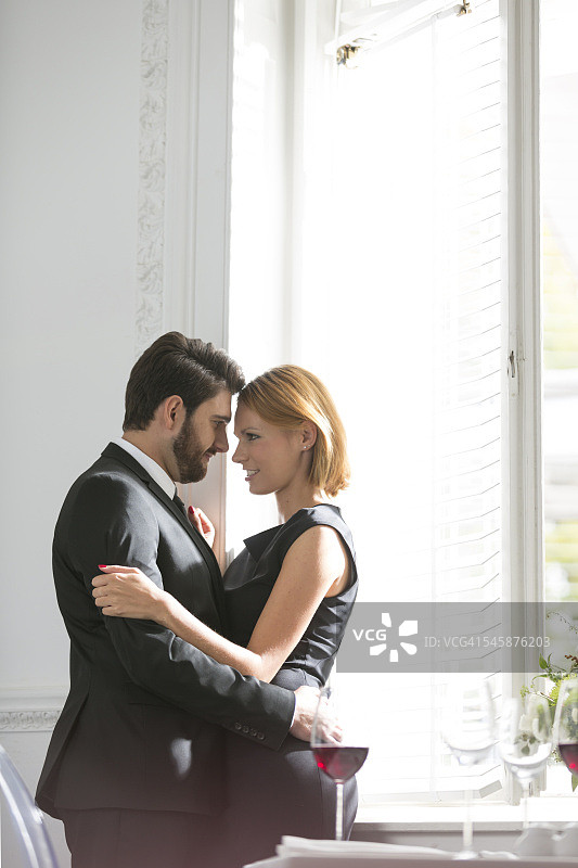 在餐厅拥抱的优雅情侣图片素材