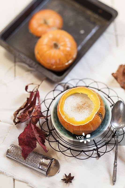 烤箱烤制的小南瓜，里面填充香料热椰奶图片素材