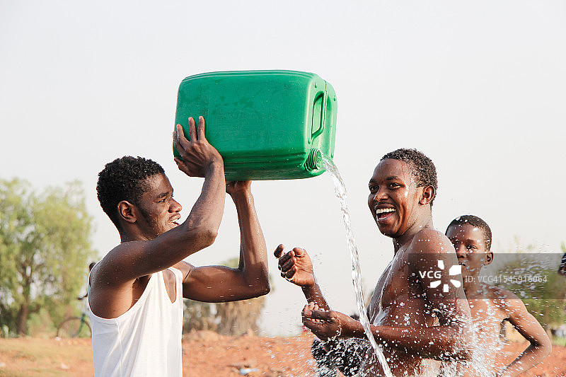 男子在河里互相泼水图片素材