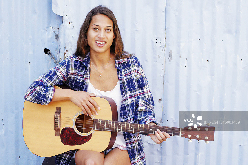抱着吉他的年轻漂亮女人图片素材