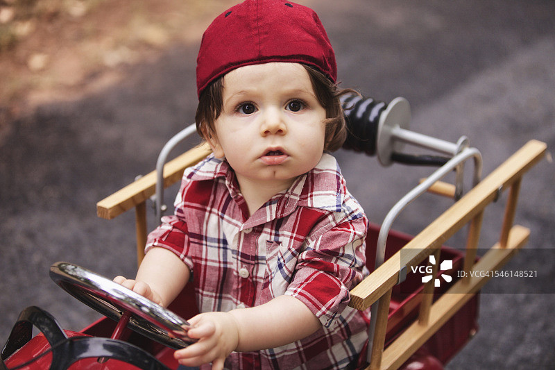 在红色消防车里看着相机的小男孩图片素材