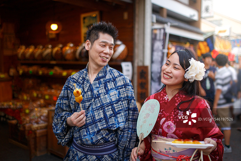 日本夫妇在传统节日街头吃团子图片素材