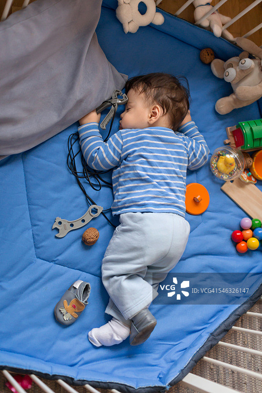在游戏围栏中睡觉的男婴图片素材