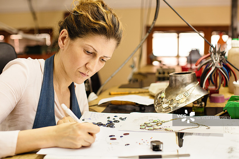 女设计师在工作室制作和设计珠宝图片素材