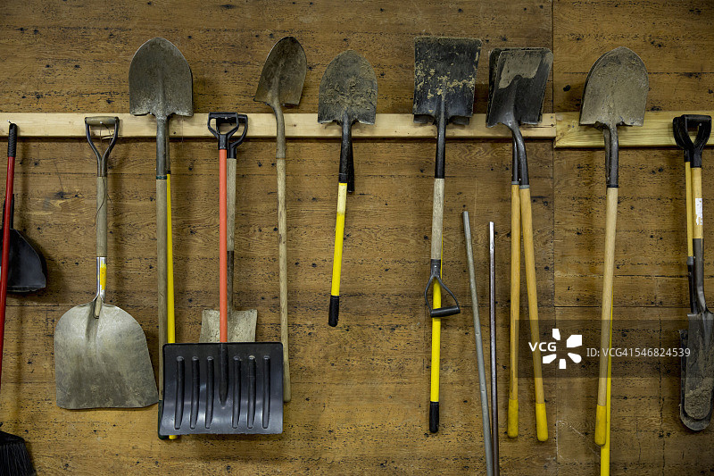 棚子里挂在钩子上的铲子和工具图片素材