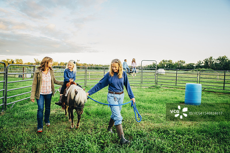 三代白人妇女在农场里遛迷你马图片素材