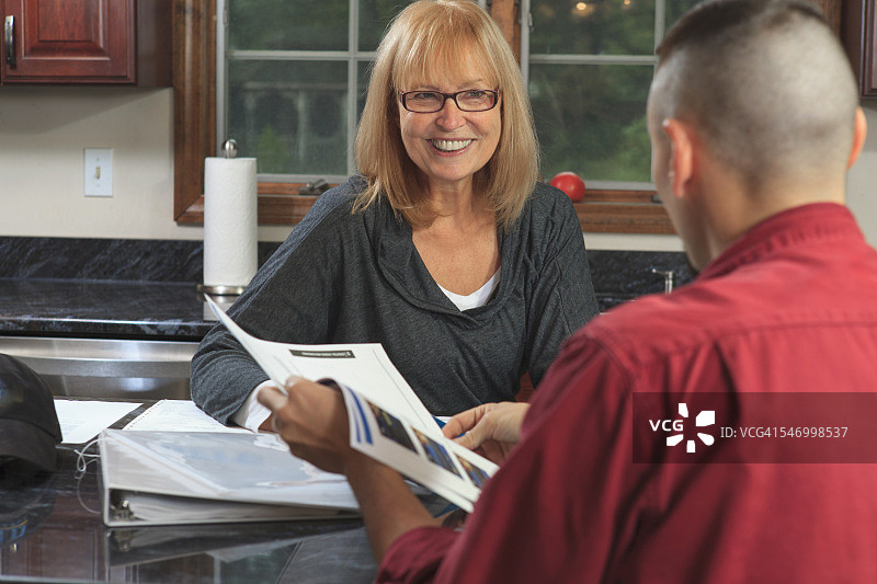 电缆安装人员与房主一起查看服务计划图片素材