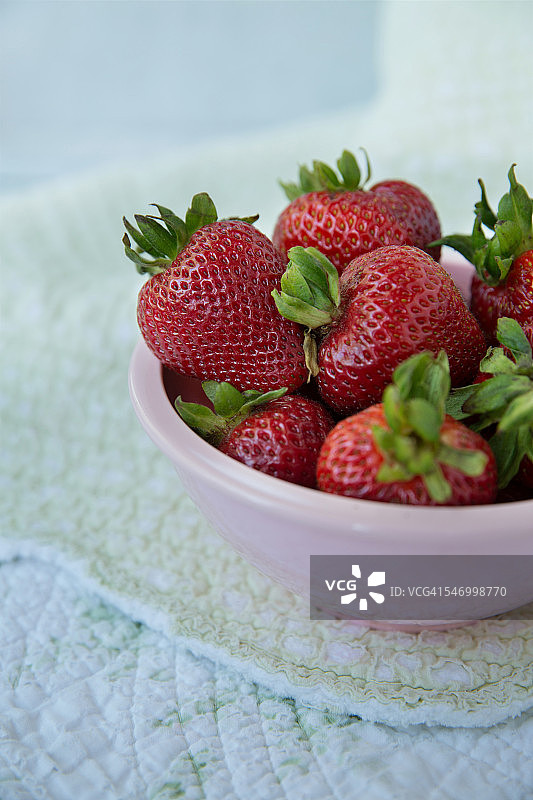 装满新鲜草莓的粉色碗图片素材