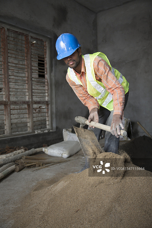 搅拌水泥的印度建筑工人图片素材