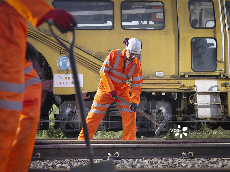 铁路维护工人在轨道上拧紧螺栓图片素材