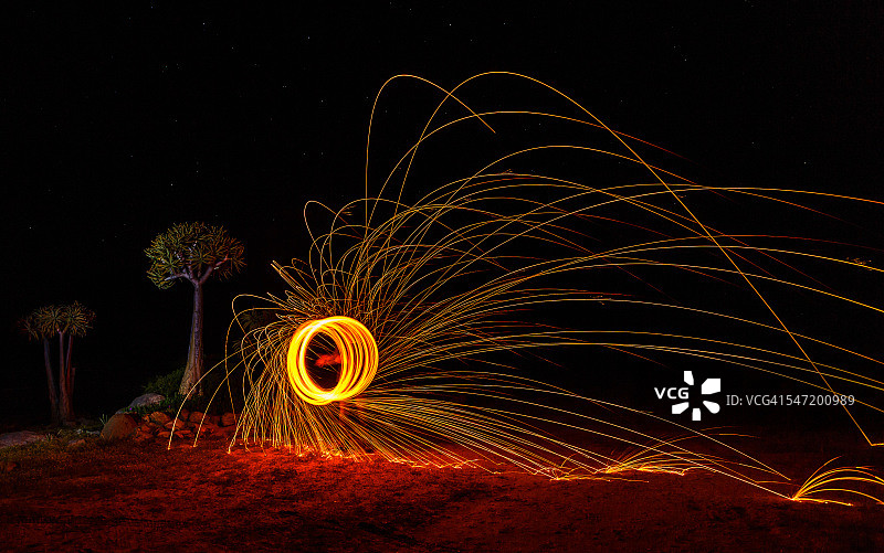 在夜间用燃烧的钢丝棉旋转产生火花，无法辨认的人，卡米斯克鲁恩，西开普省，南非图片素材