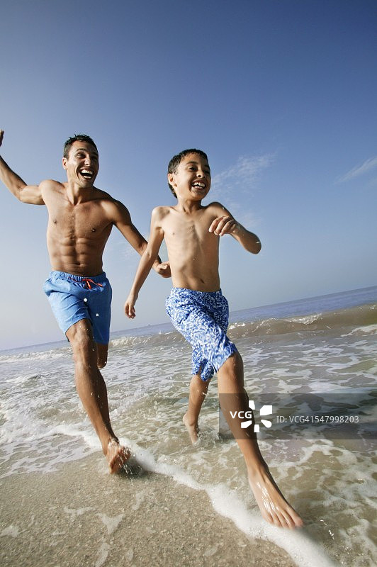 父子在海滩上跑步图片素材