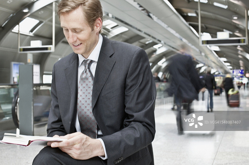 在机场航站楼阅读的男商人图片素材