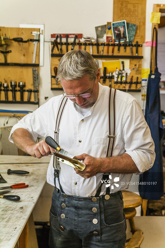 马鞍匠调整皮革切割器图片素材