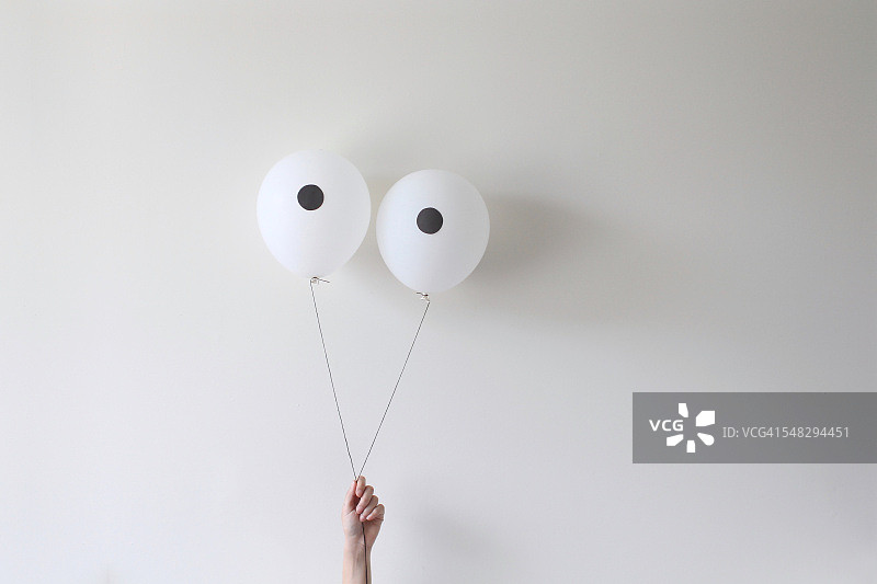 手持一对眼睛气球图片素材