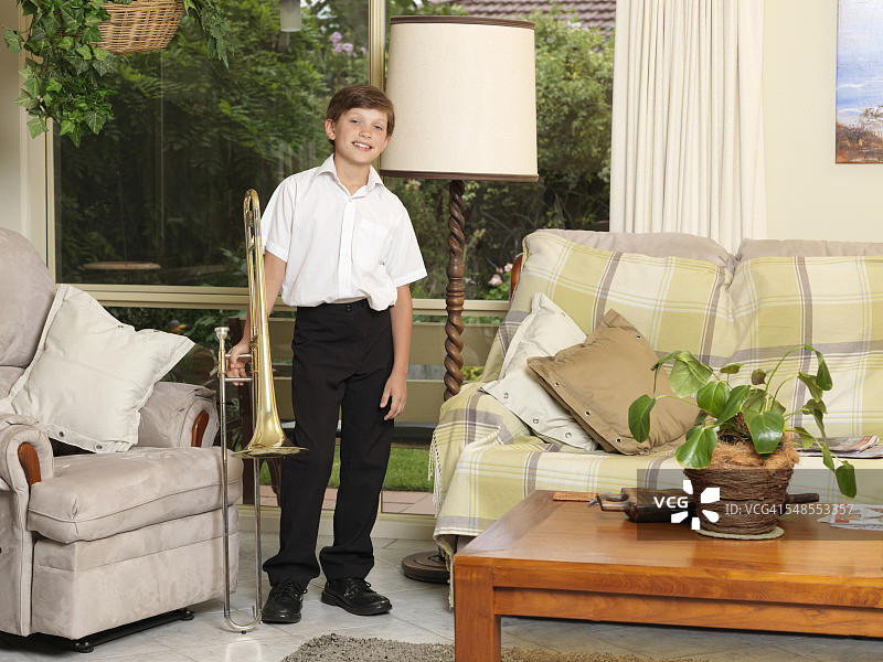 男孩在客厅里拿着长号肖像图片素材