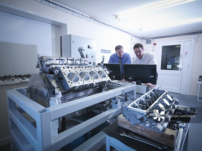 在测试设备中检查汽车发动机的工程师图片素材