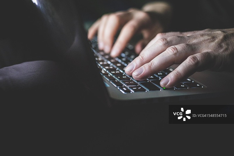 中年男人使用笔记本电脑，专注于手部图片素材