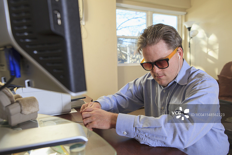 先天失明的男人使用电脑辅助技术听取信息图片素材