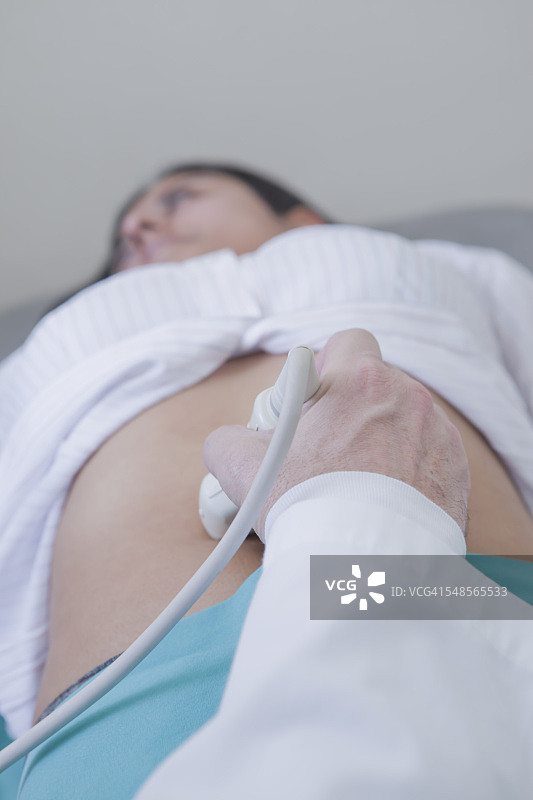 超声技师用探头检测女性腹部图片素材