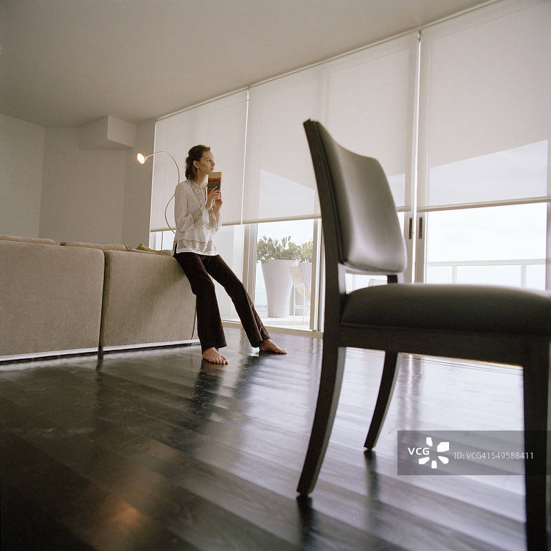 女人在客厅里拿着书图片素材