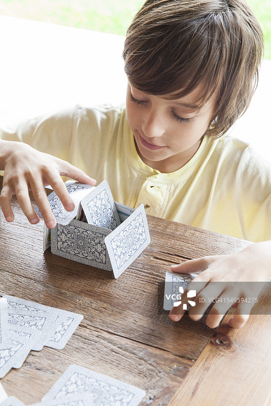 男孩搭建纸牌屋图片素材