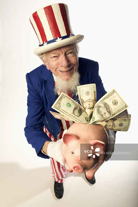 山姆大叔拿着小猪存钱罐图片素材