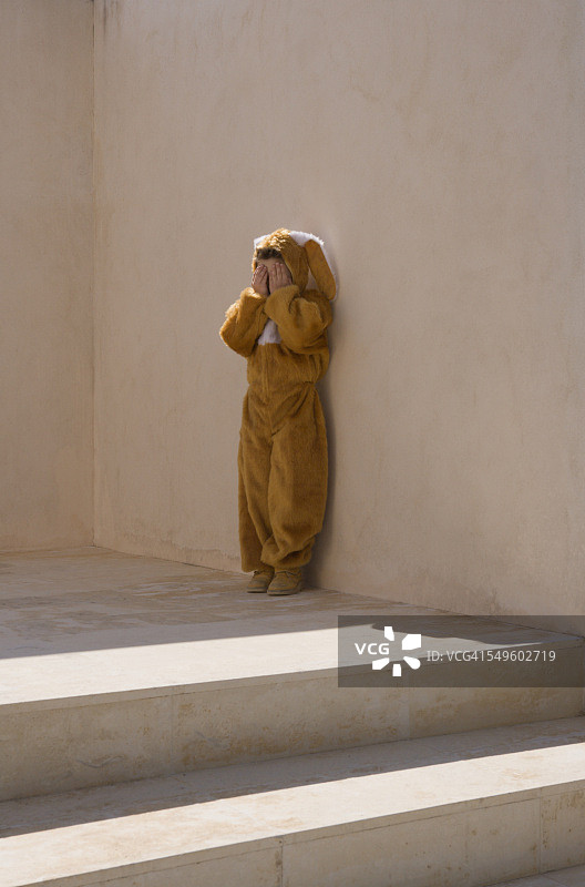 藏在兔子服装里的男孩图片素材