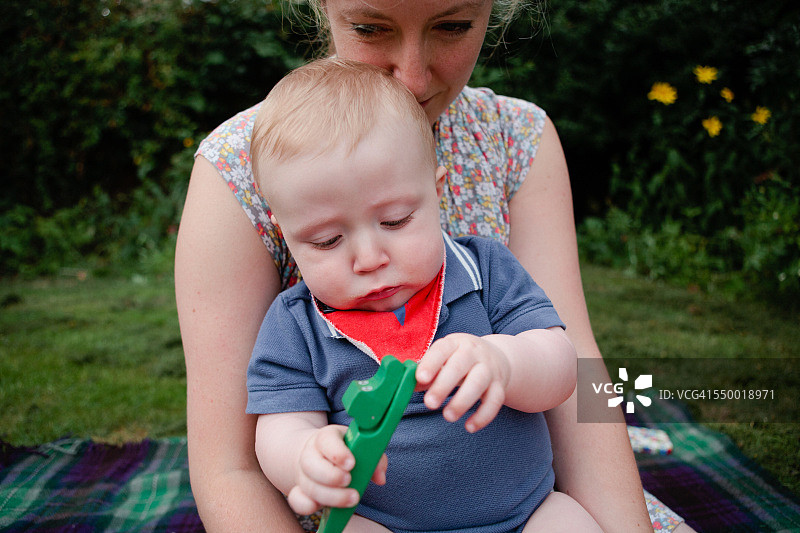婴儿和妈妈坐在花园里图片素材