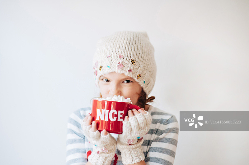 在印有“尼斯”字样的杯子里喝热巧克力的女孩图片素材