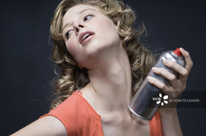 年轻女子喷洒发胶图片素材