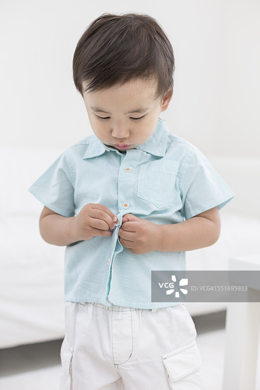 男孩在扣衬衫图片素材