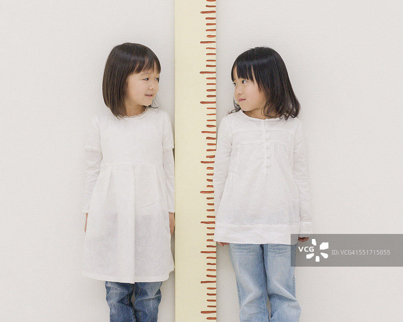 两个女孩量身高图片素材
