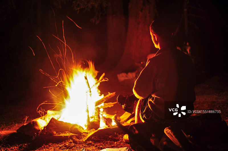 男子坐在篝火旁图片素材