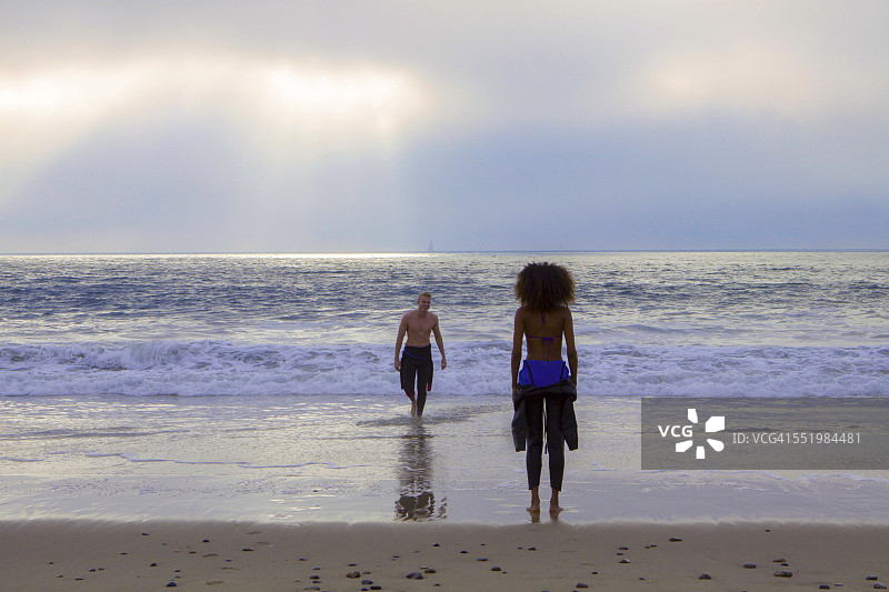 年轻女人在海滩上等候冲浪的男友（美国加利福尼亚州雷伊海滩）图片素材