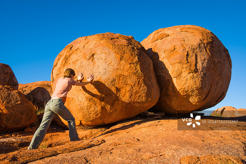 女人在澳大利亚内陆推动魔鬼大理石图片素材