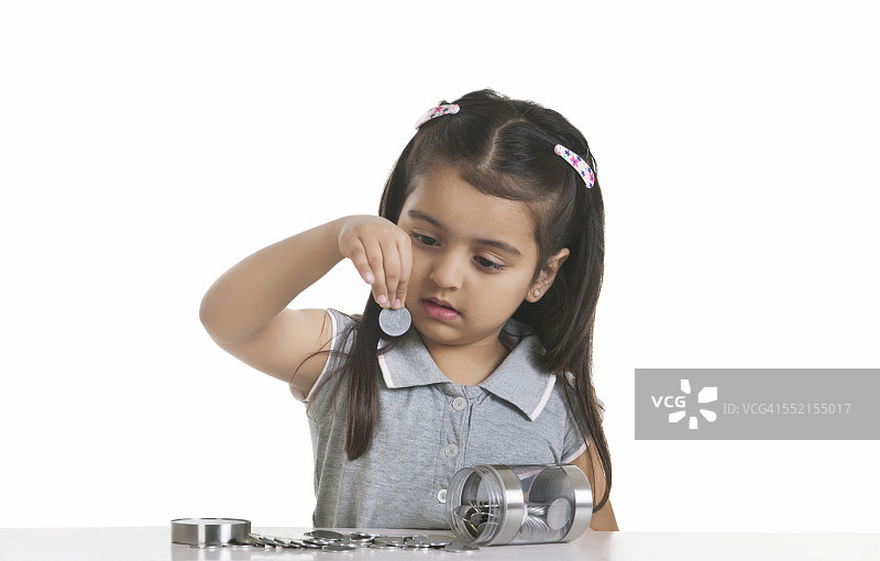 女孩看着印度硬币，白色背景图片素材