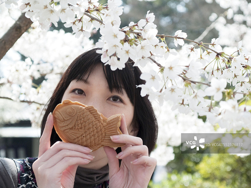 手拿鲷鱼烧的女人图片素材