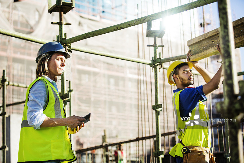 建筑师观看工人在现场工作图片素材