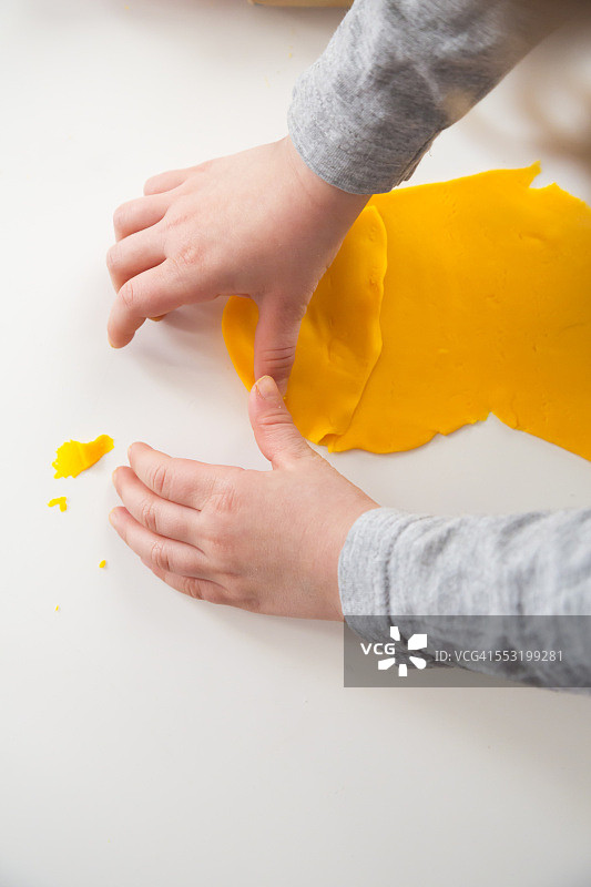 玩黄色橡皮泥的小女孩图片素材