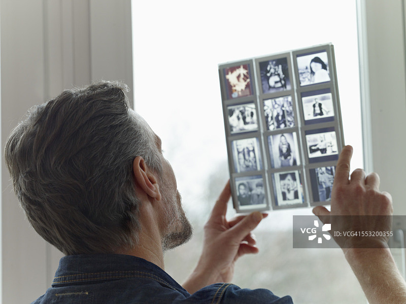 看旧幻灯片的中年男人图片素材