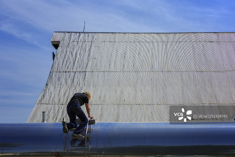 在奶牛场检查牛奶罐车的农场主妻子图片素材