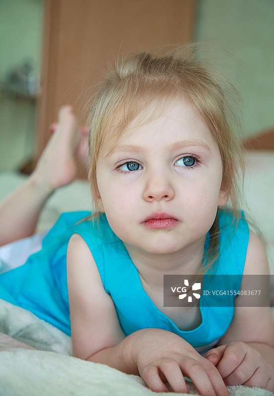 沉思的小女孩躺在床上图片素材